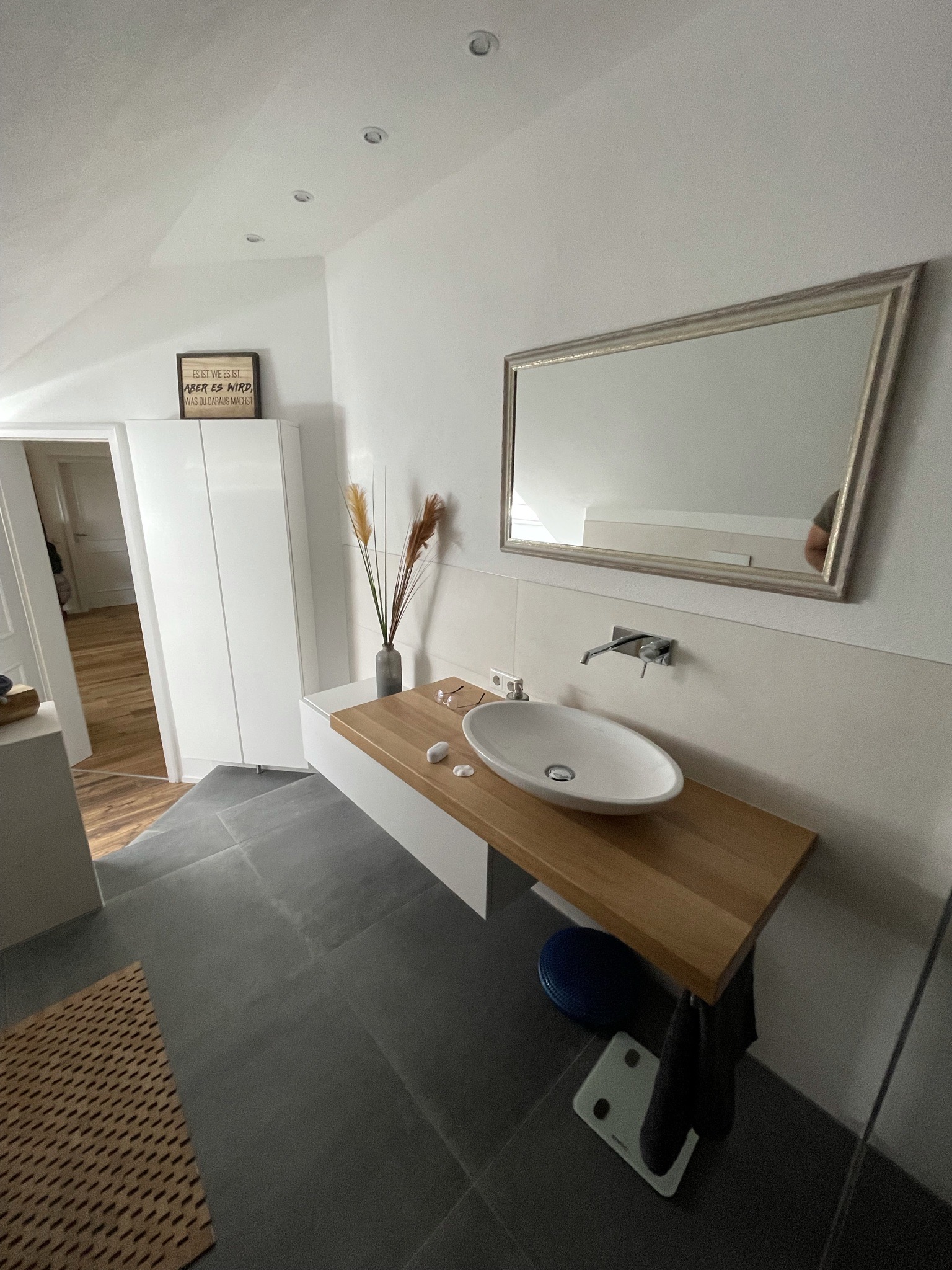 Bad im Schlafzimmer: freistehende Badewanne mit Fliesen in Holzoptik