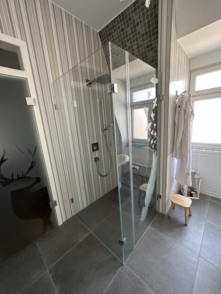 Begehbare Dusche mit Glasabtrennung und Regenduschkopf im Elternbad