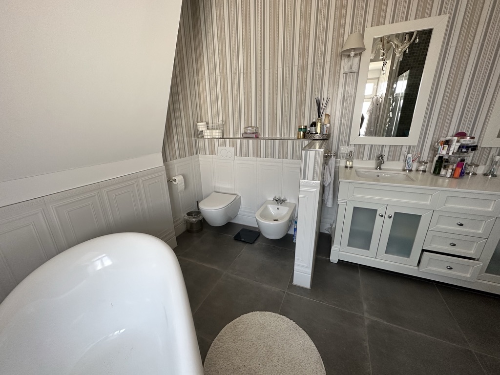 WC und Bidet hinter eleganter Trennwand im Elternbad