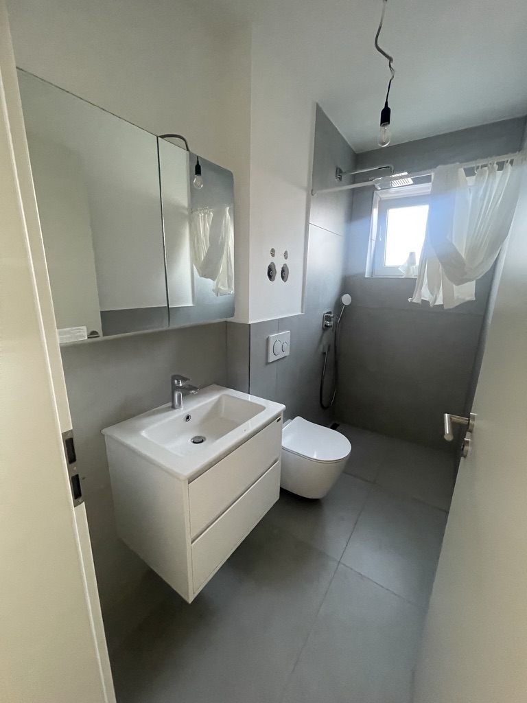 Dachgeschoss-Bad mit begehbarer Dusche, hängendem WC und beleuchtetem Spiegelschrank