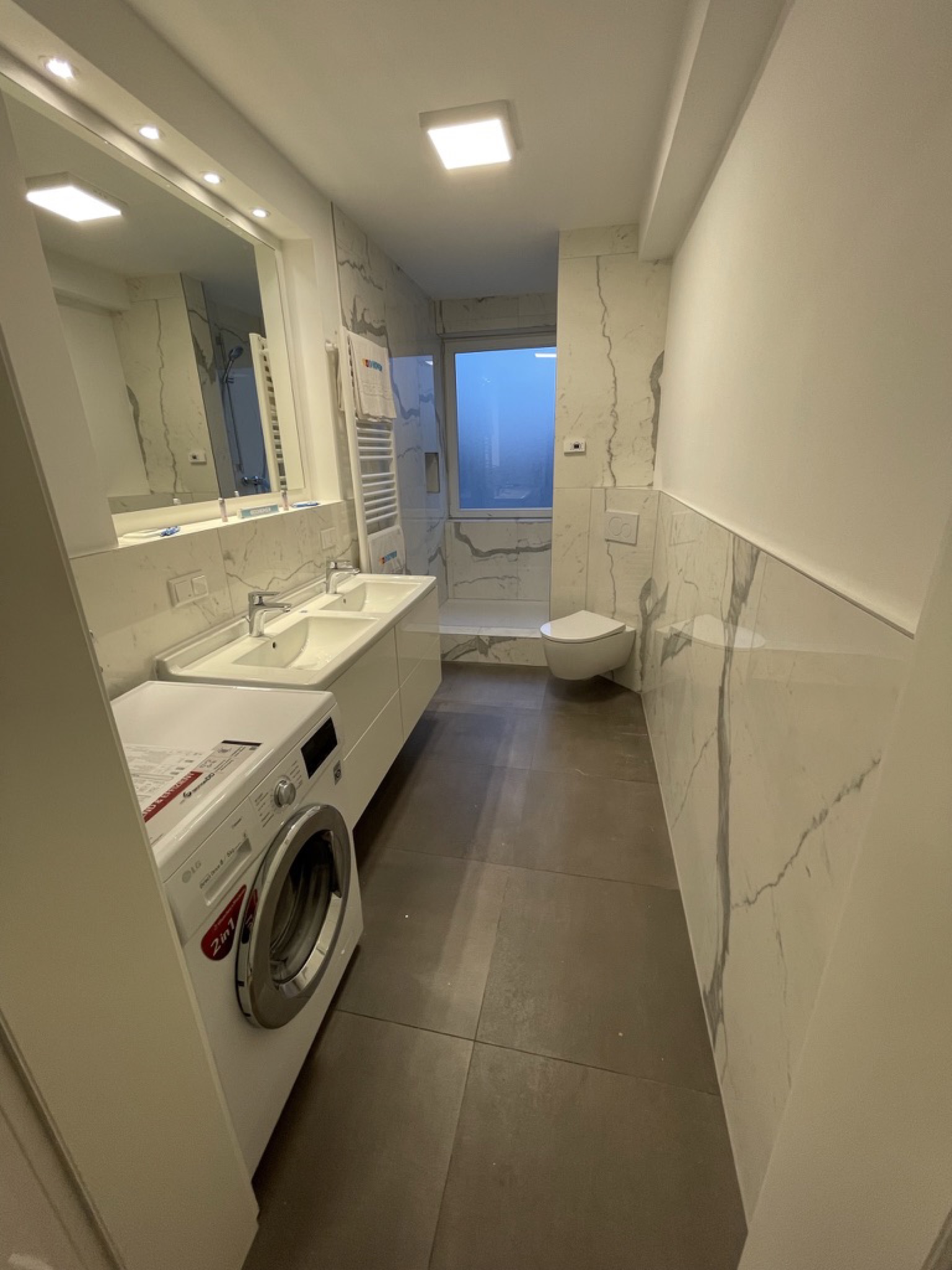 Fertiges Hauptbad mit Dusche, Doppelwaschtisch, Eck-WC und Handtuchheizkörper